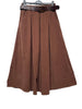 Introducing the 91208 Flared Skirt in Fine-Wale Corduroy with Belt: Choco by LINEN & COTTON HOUSE—a brown, knee-length skirt featuring a flared silhouette, pleats, two side pockets, and a dark brown belt, beautifully displayed on a hanger against a white background. This stylish piece is perfect for fall and winter wardrobes.